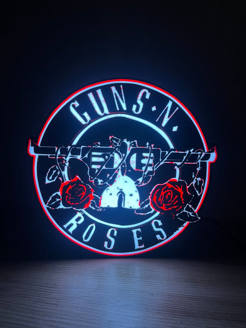 Actual circular Guns N Roses lightbox with white lettering and red roses on a dark desk.